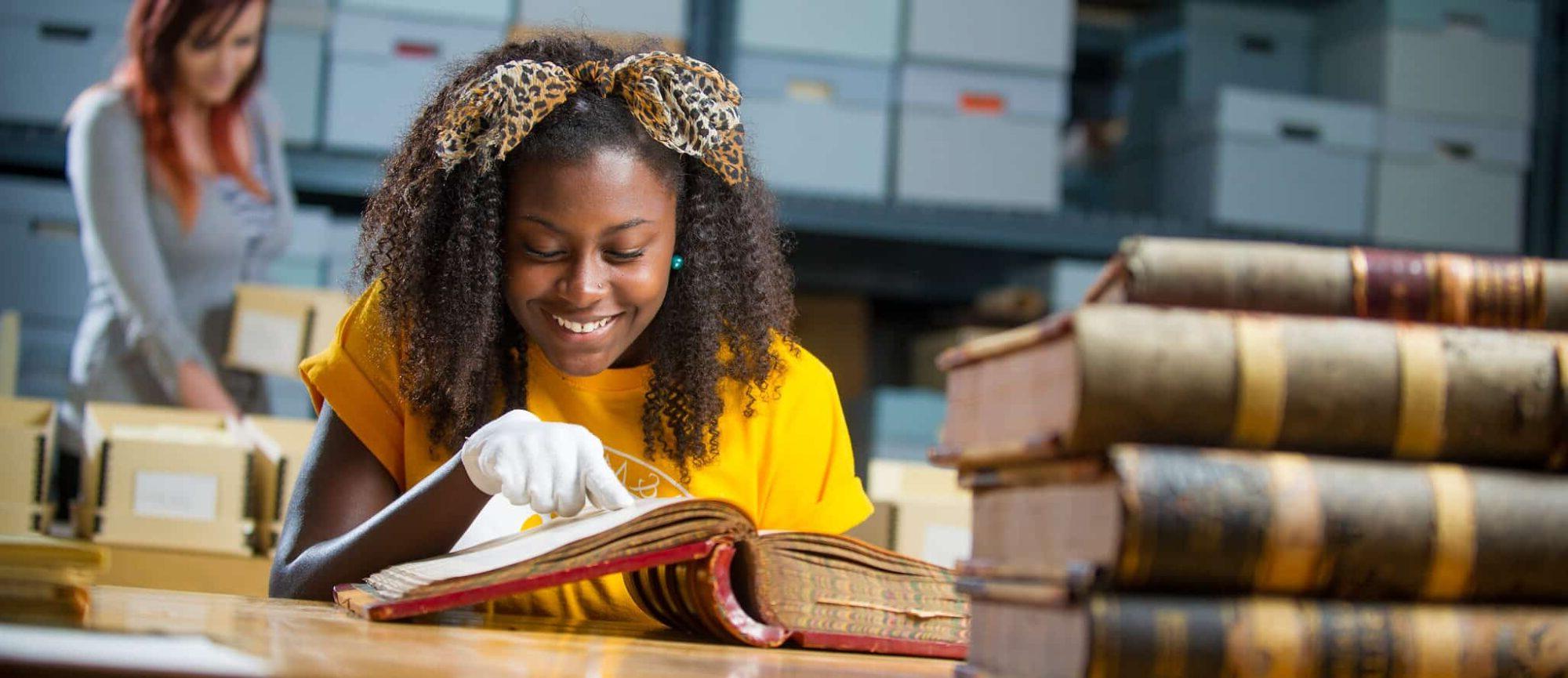 Student examining historic book.