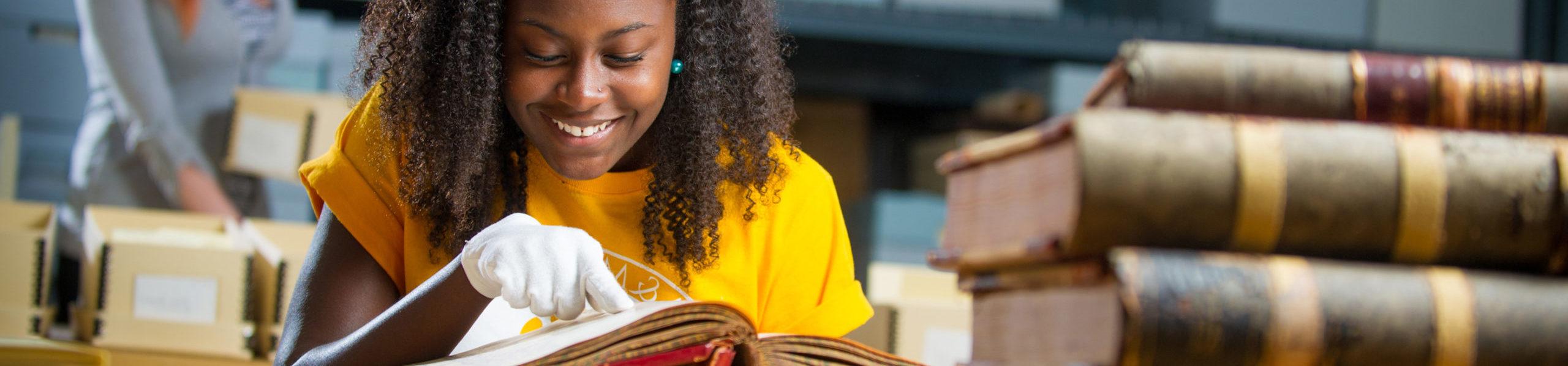 Student examining historic book.