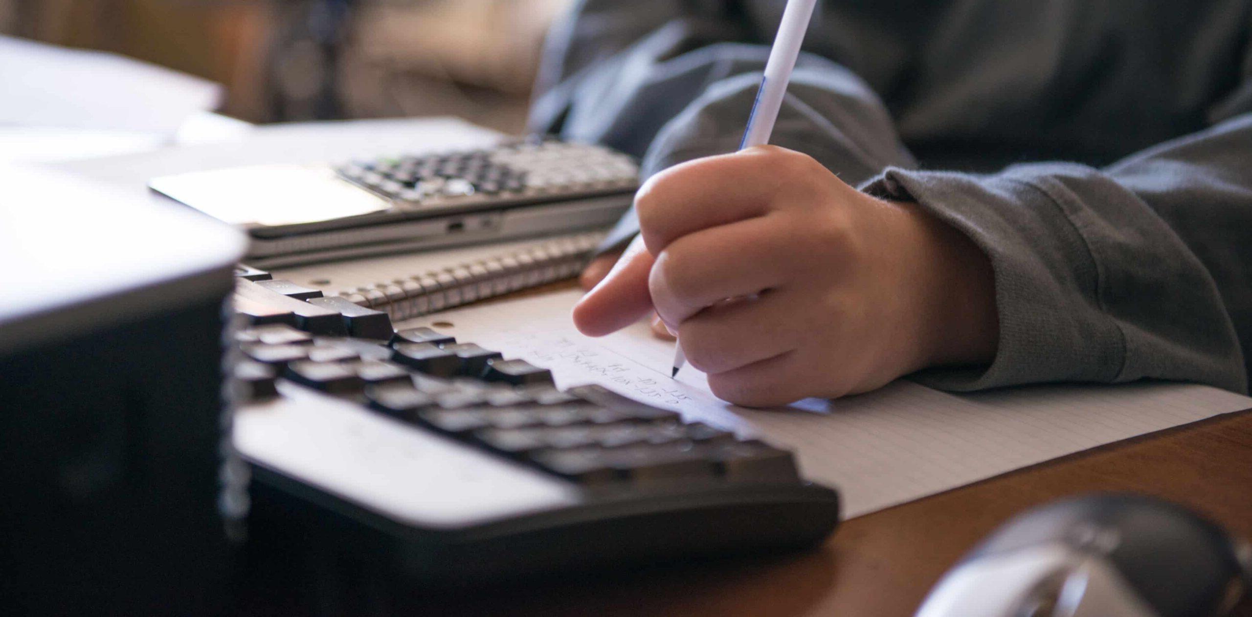 Math student writing in front of computer