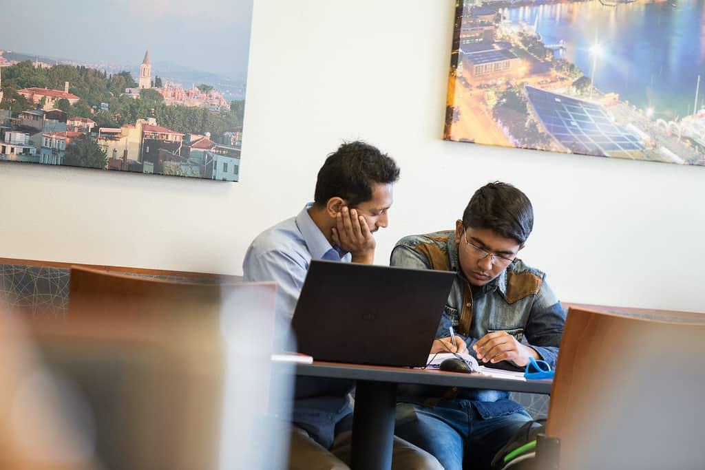 Professor helping student at table