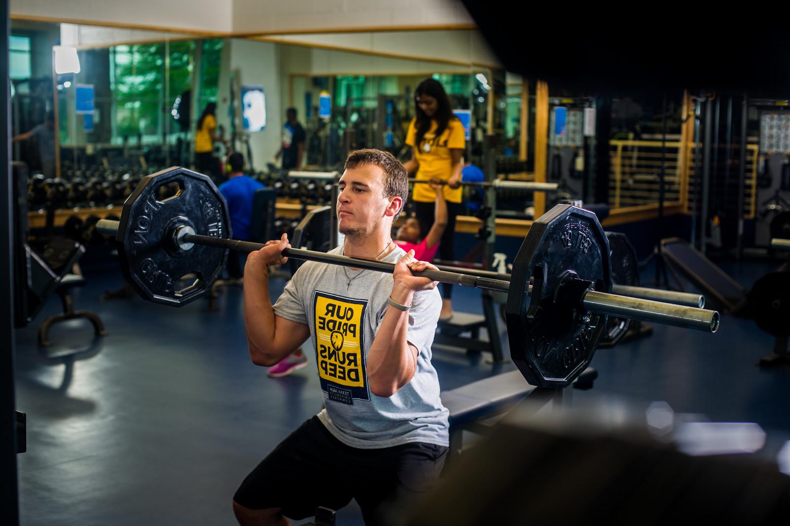 Male student power lifting in rec center