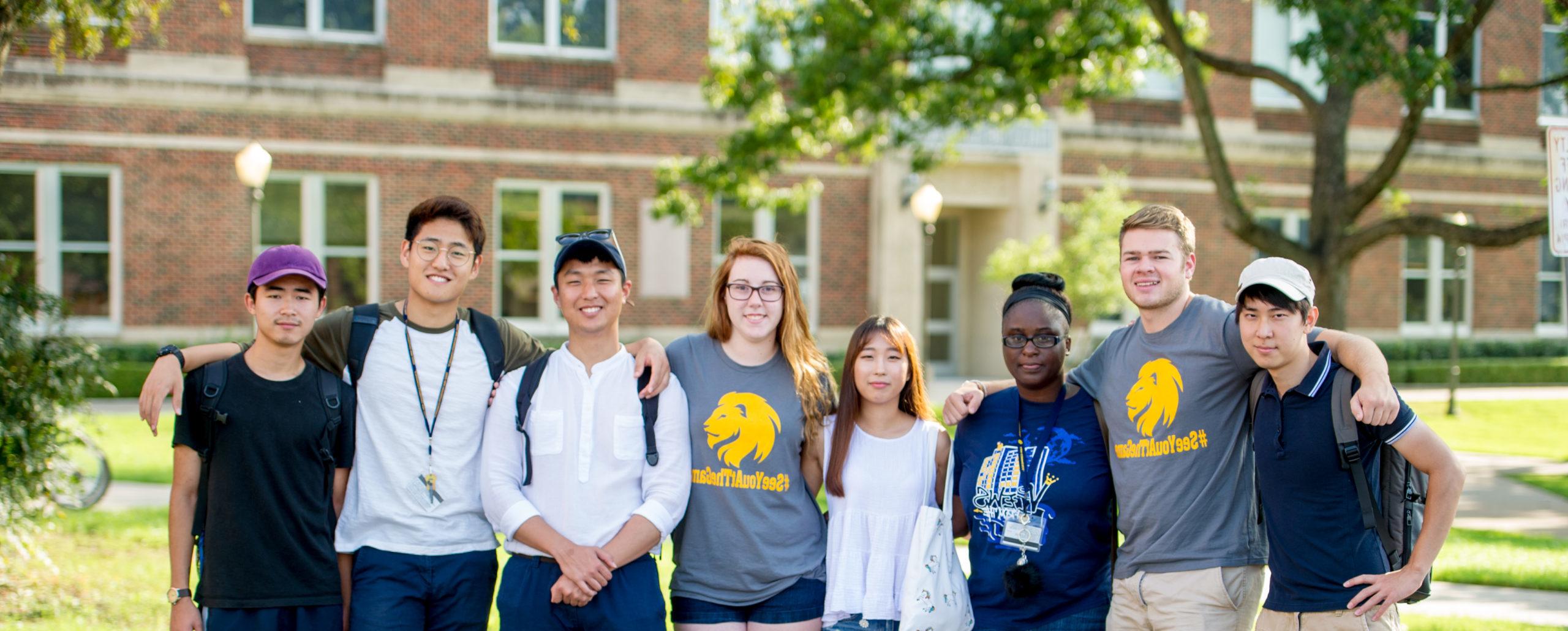 A group of eight A&M-Commerce students friendly hugging each other for a photo.