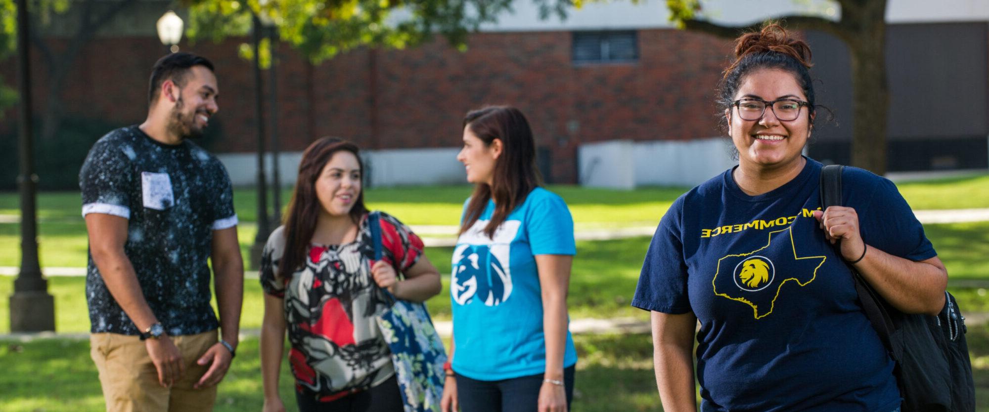 Diverse group of students with female student looking directly at camera.