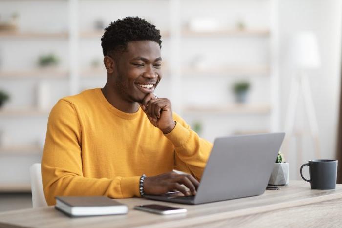 happy black guy project manager typing on laptop keyboard