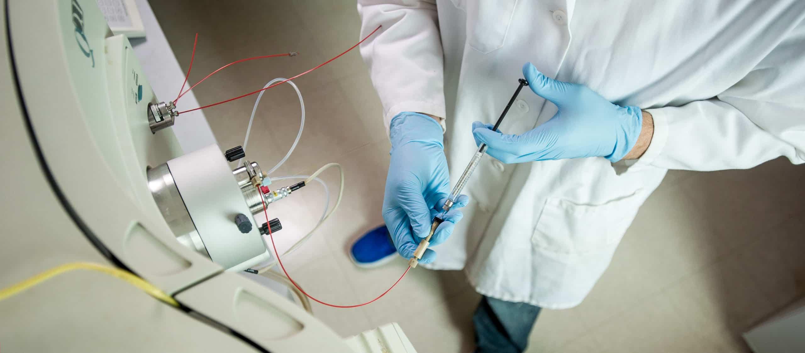 Chemist injecting fluid into a large mechanical system