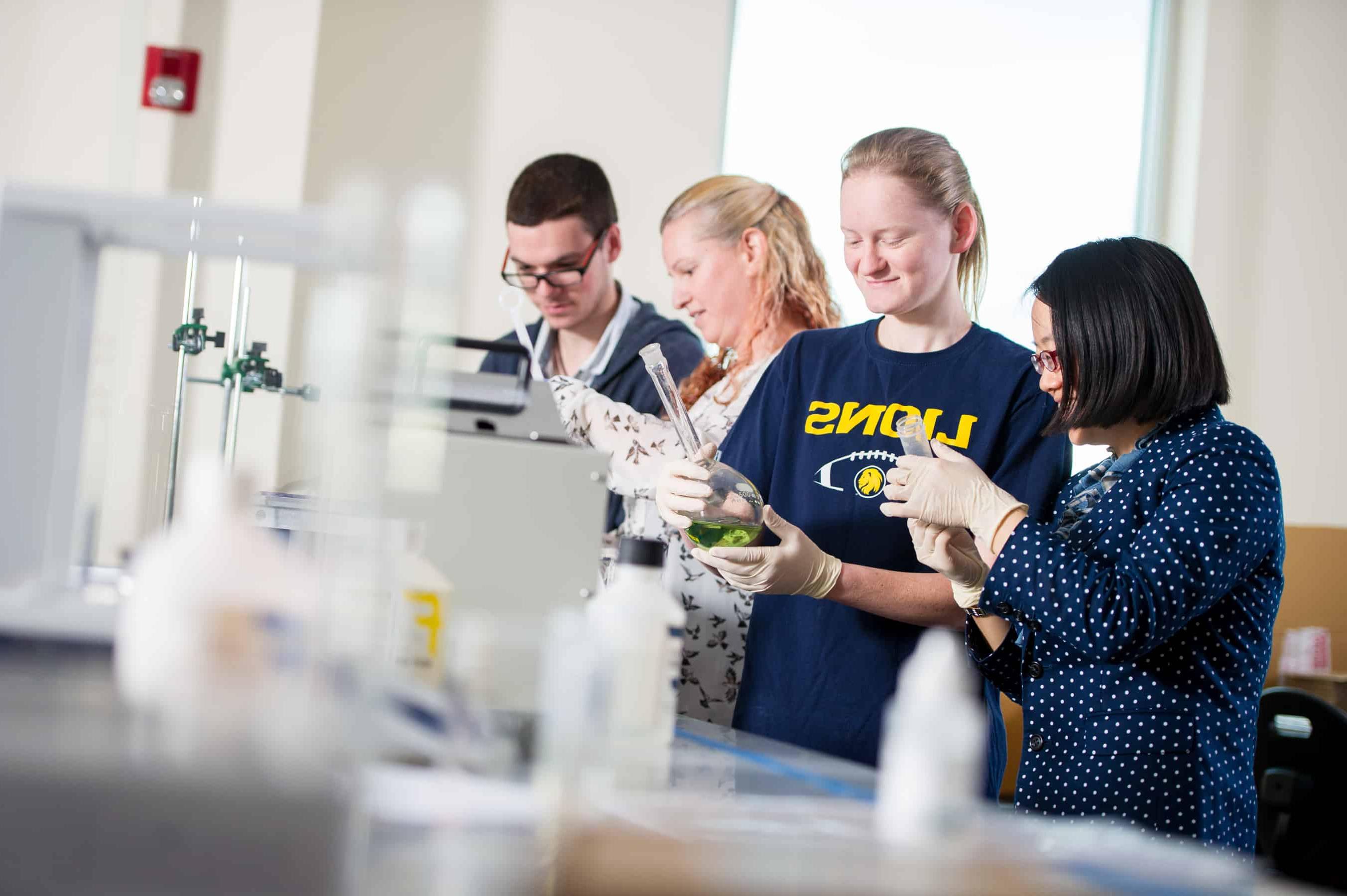 Chemists inspecting green liquid in flask