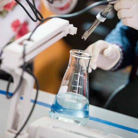 Chemist inserting sensor into a filled erlenmeyer flask