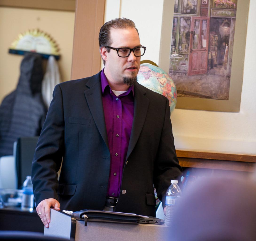 Man speaking to a classroom of individuals.