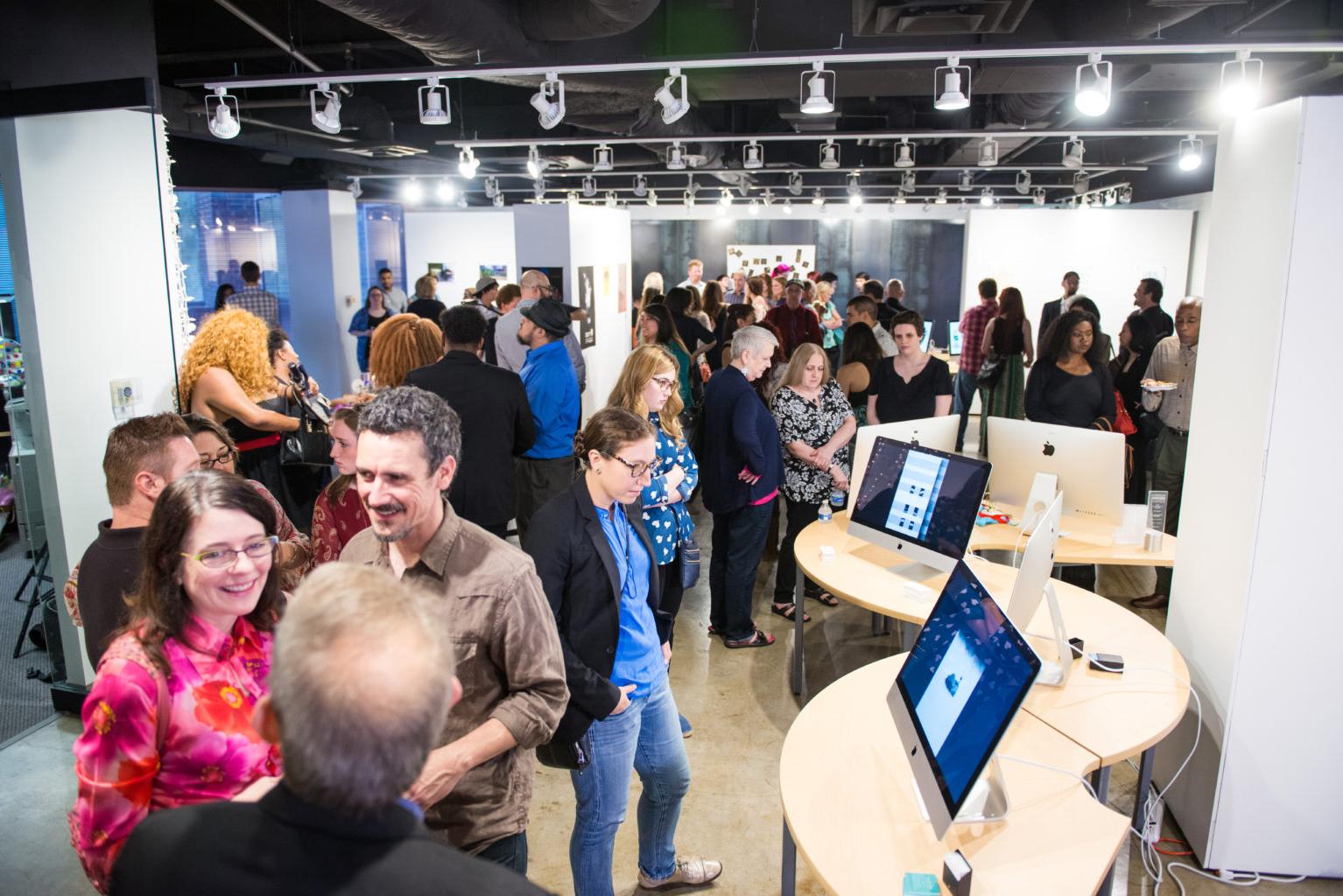 large group in art gallery with computer screens