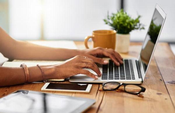 Shot of an unrecognizable woman working from home.