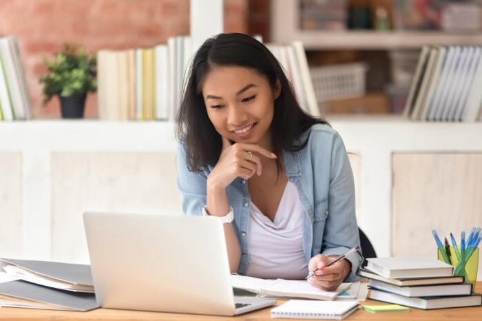 Woman sitting down in front of a computer smilling.