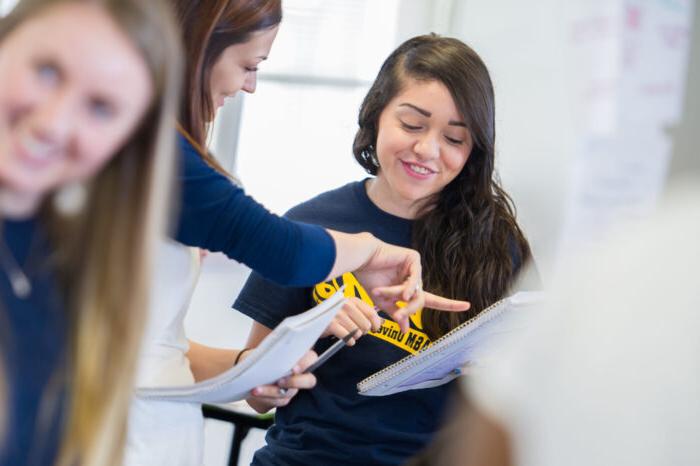 two females working with tablet in class.