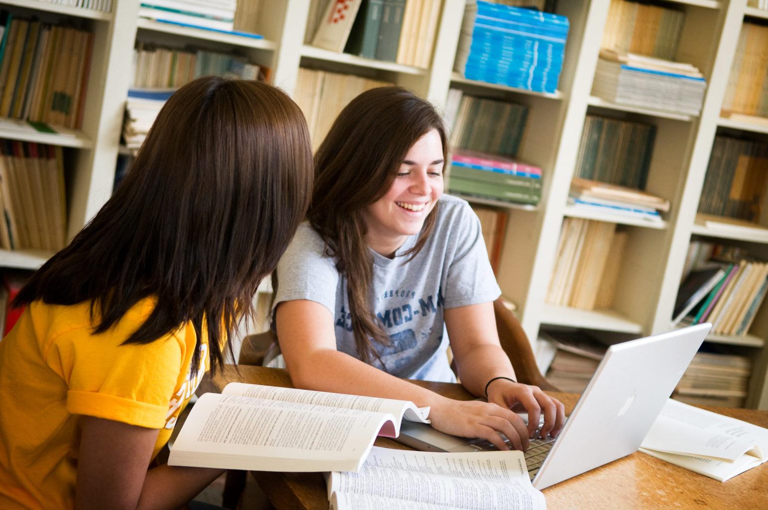 Two students doing homework in the library.