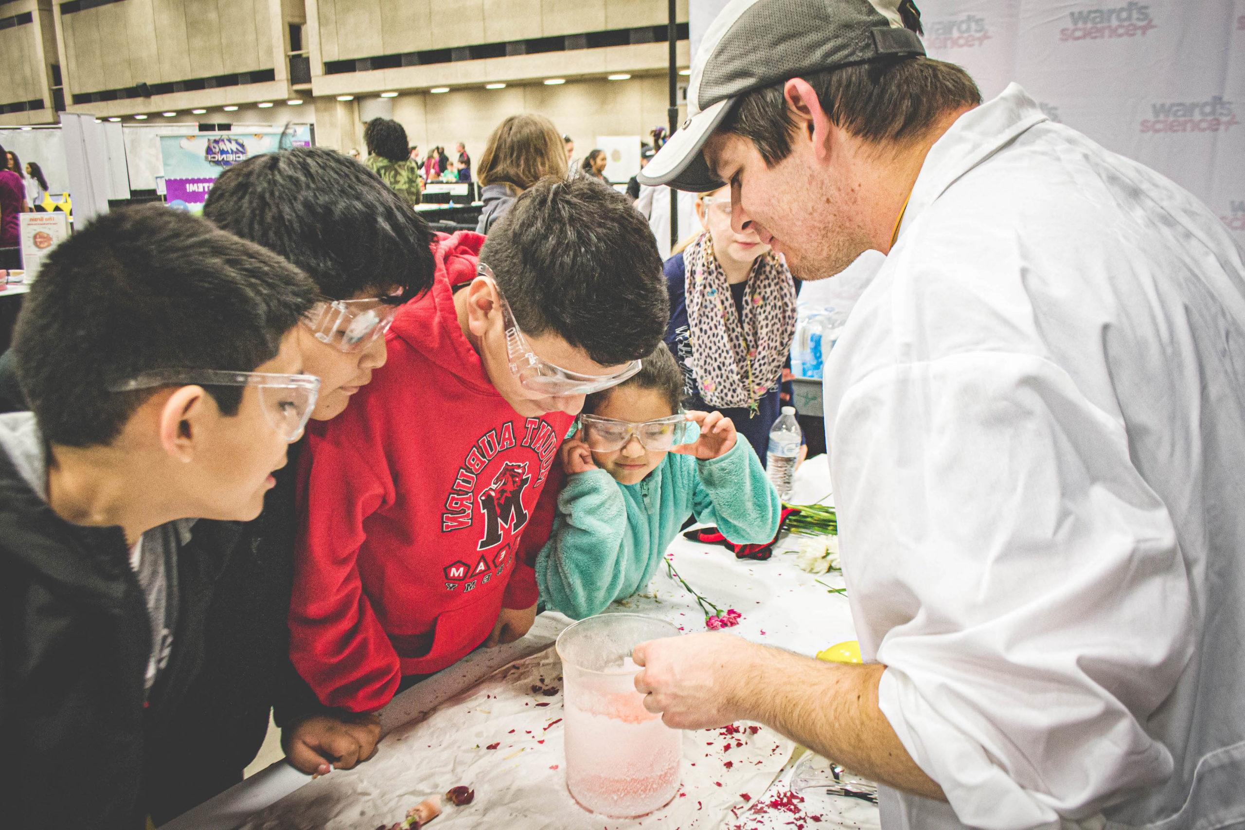 Students engaged in a science experiment that is being instructed by the instructor.