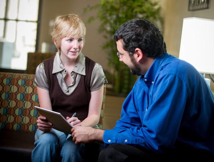 Woman counselor mentoring male student.