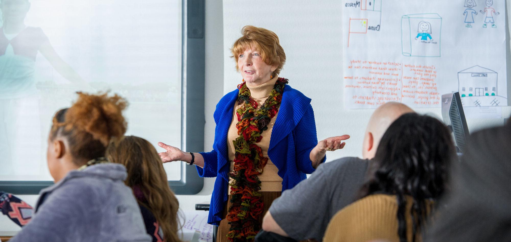 Woman teaching classroom full of college students