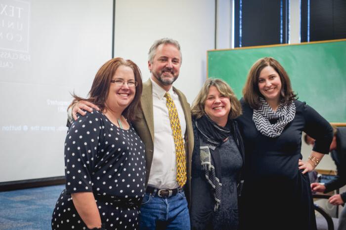 Group of professors standing in a classroom.