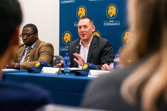 TAMUC Alumni talking to current students during an event.