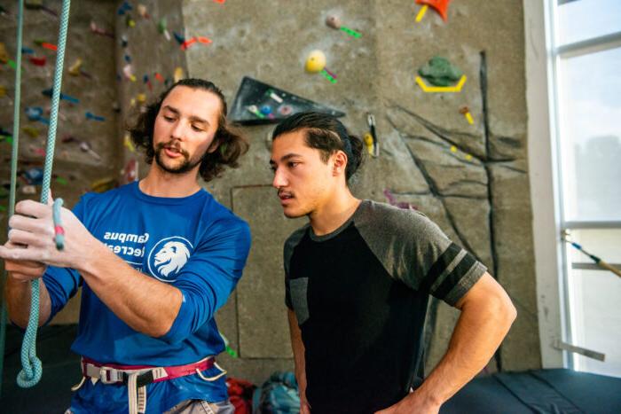 Rock climber instructing a student.