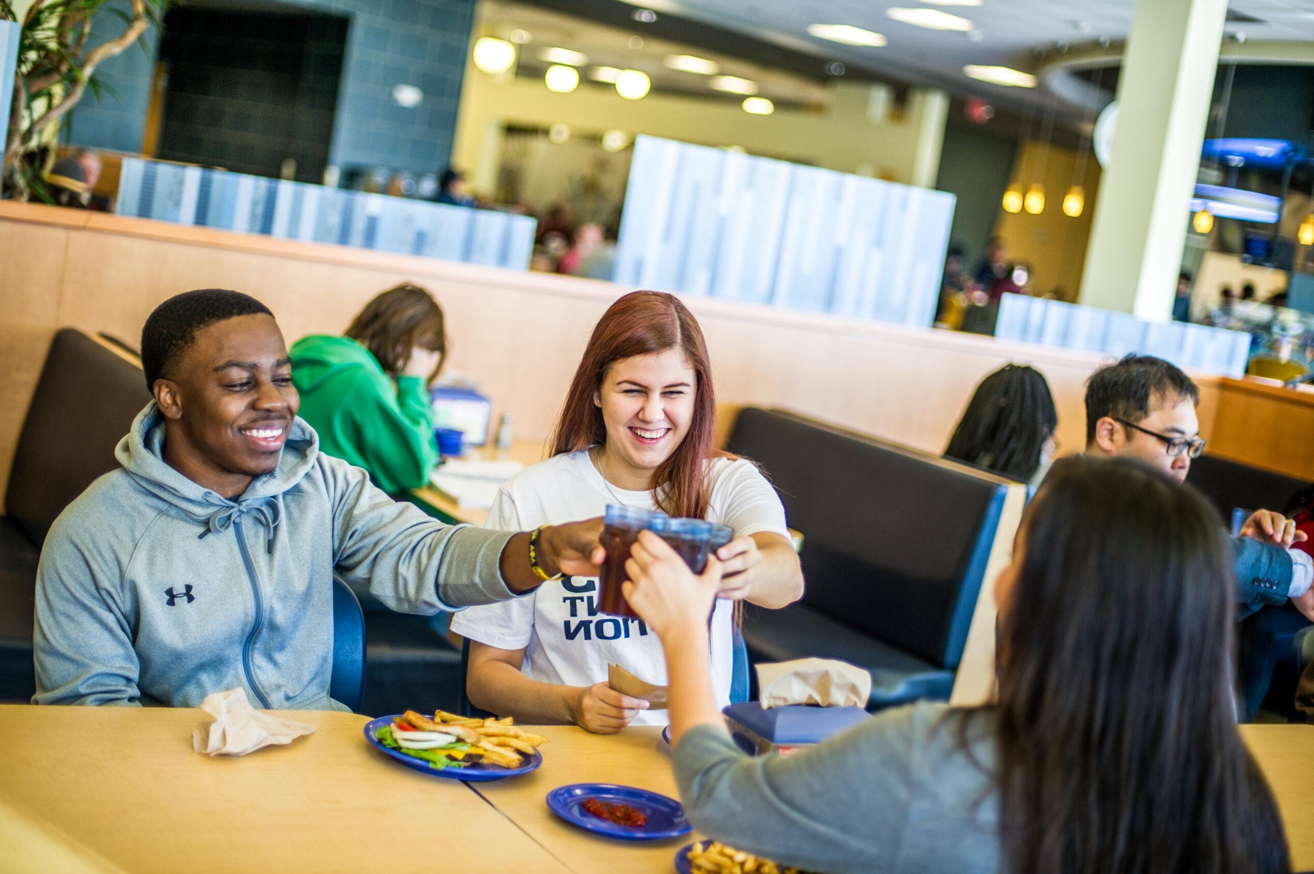 A few students having a pop together in the cafeteria.