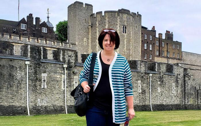 A female in front of a castle.