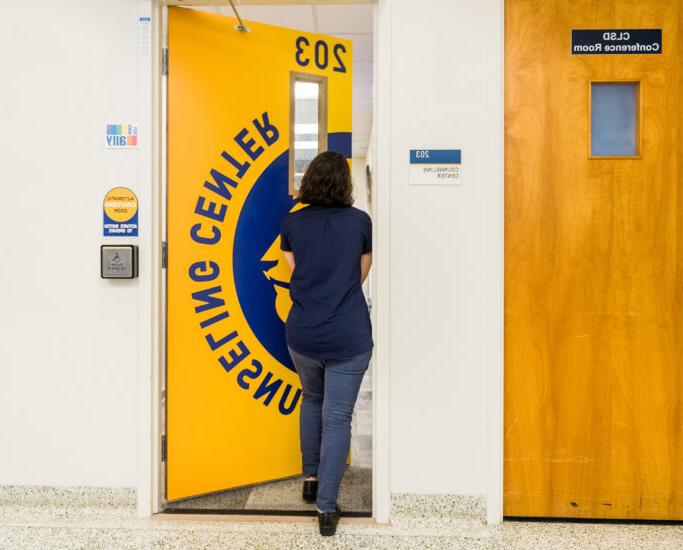 Student entering the door to access the counseling center on campus.