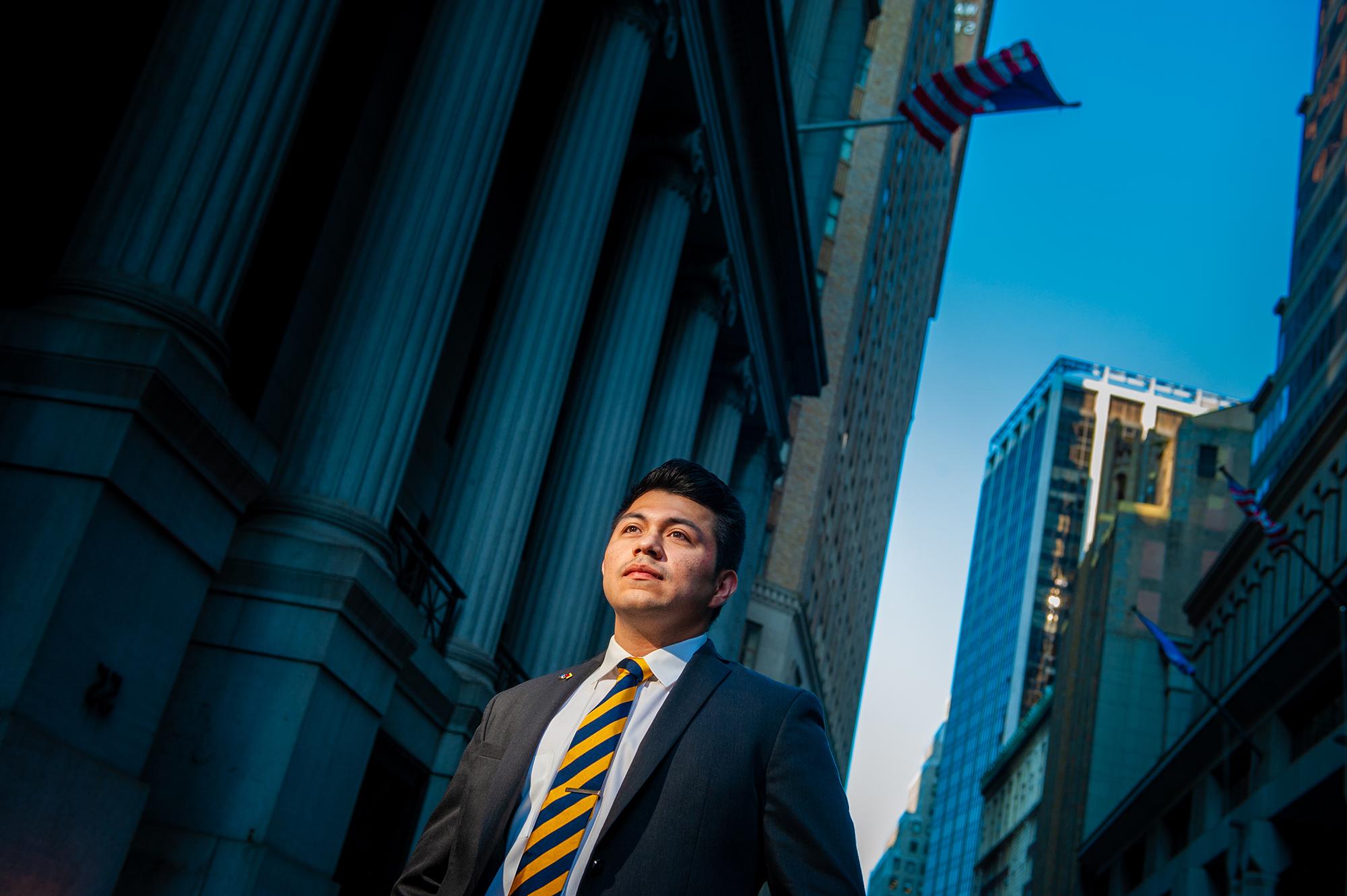 Student in a power suite in front of a building like on Wall Street.