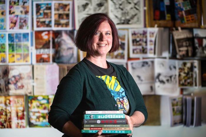 A professor standing with books