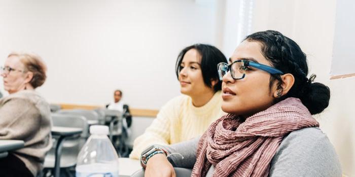 Two female students looking in the same direction in class. 