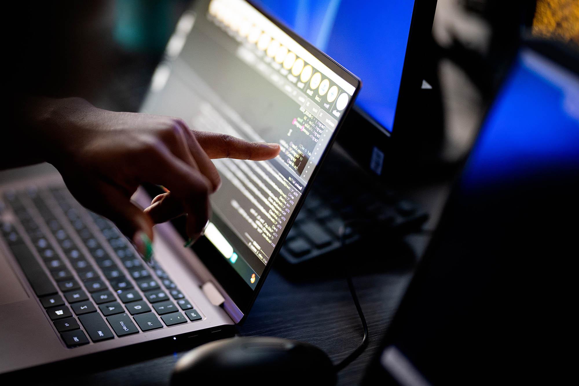 Close-up of a student coding on a laptop during a collaborative computer science class at East Texas A&M University.