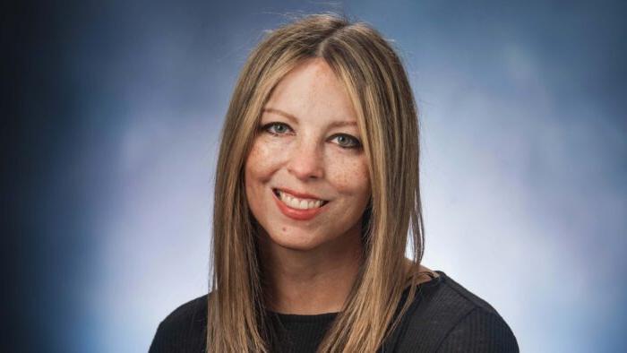 A woman smiles at the camera in a headshot photo.